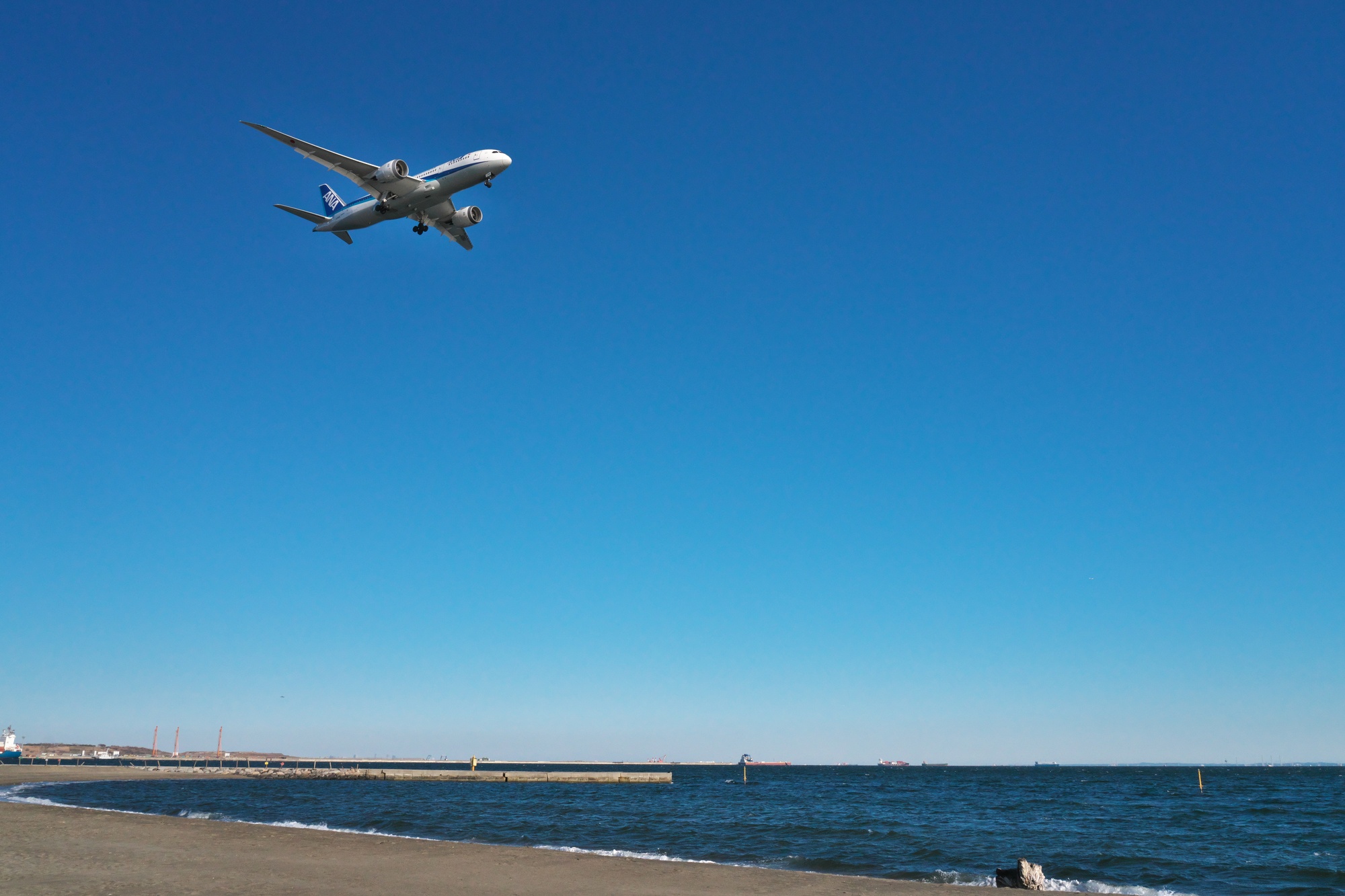 つばさ浜上空を飛ぶ飛行機